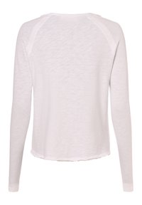 Weißes Damenlangarmshirt mit Rundhalsausschnitt und rohem Saum, von hinten vor einfarbigem Hintergrund gezeigt.