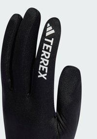 Svarta handskar med en jämn textur, med ordet "TERREX" i vitt på ovansidan och en åtsittande design för värme och grepp.