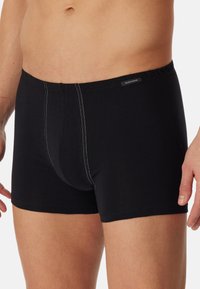 Shorts de boxeurs noirs en tissu doux et extensible avec une taille élastique. Présentent des coutures contrastantes et un design ajusté et moulant.