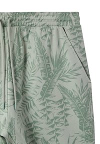 Pantaloni della tuta verde chiaro con motivo a foglie, vita elasticizzata con cordino, tasche laterali e tessuto morbido e testurizzato.