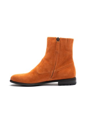 Suede ankle boot in orange with a side zipper, rounded toe, and a textured surface. Rubber sole with low heel for stability.