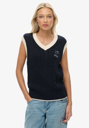 Chaleco sin mangas azul marino con patrón de trenzas, con ribete en V color crema y logo de "Superdry" en el pecho. Dobladillo y bordes de las mangas de punto acanalado.