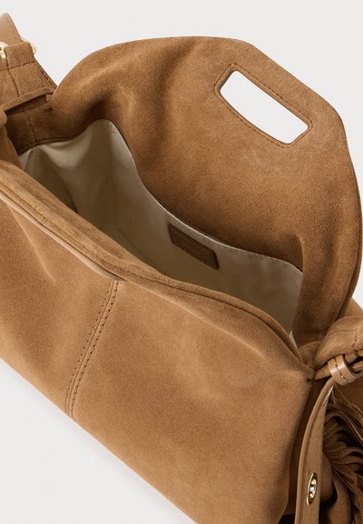 Sac à main en daim marron doux avec poignée découpée et poche intérieure en tissu beige, vu d'en haut.