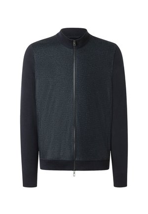 Giacca navy con zip, corpo texture e maniche lisce, dotata di colletto alto e polsini e orlo a coste.