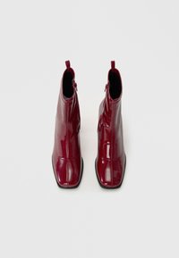 Bordo lakuotos odos aulinukai su kvadratiniu pirštu, šoniniu užtrauktuku ir elegantiška siluetu. Glotni tekstūra ir minimalistiškas dizainas.