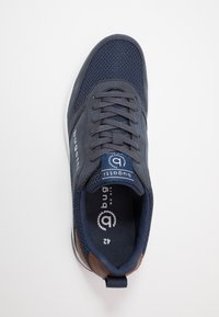 Navy blue athletic shoe with mesh and suede materials. Features round laces, padded collar, and brown accents on the heel and side.