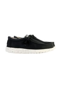 Scarpe slip-on nere con tomaia a trama e suola bianca maculata in contrasto. Presentano un dettaglio con lacci e una fodera interna decorata.