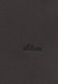 Dunkelgrauer Stoff mit glatter Textur, der ein eingesticktes s.Oliver-Logo in Schwarz zeigt. Einfaches Design ohne Muster oder zusätzliche Akzente.