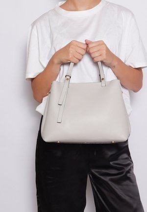 Graue, genarbte Lederhandtasche mit zwei oberen Griffen, einem abnehmbaren Trageriemen und goldfarbenen Hardware-Details. Glatte Textur mit runder Form.