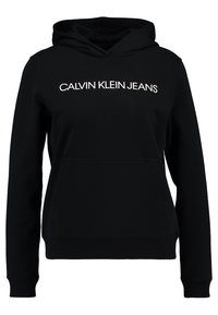 Felpa nera con cappuccio dotata di tasca a marsupio, cappuccio con cordino e stampa bianca "CALVIN KLEIN JEANS" sulla parte anteriore. Tessuto morbido e polsini a coste.