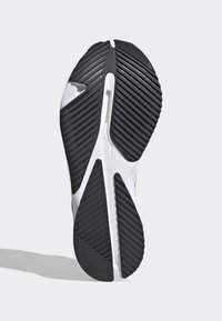 Black and white athletic shoe sole with a textured pattern, featuring deep grooves for traction and a central vent for flexibility.