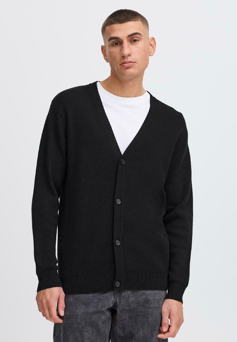 Black cardigan made of textured fabric, featuring a V-neck, long sleeves, and six button closures down the front.