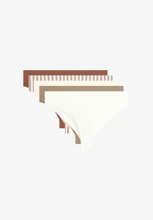 Kvinde iført sømløse hipster-trusser i nøgenfarve mod en ensfarvet lys baggrund, der viser taljen til øvre lår.