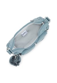 Ljusblå zippered väska i texturerad tyg. Har en mjuk pälspom-pom charm och en logotagg inuti. Kompakt och funktionell design.