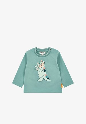 Light turquoise long-sleeve shirt featuring a cartoon bear in a onesie with colorful pom-poms down the back and side snap closure at the collar.