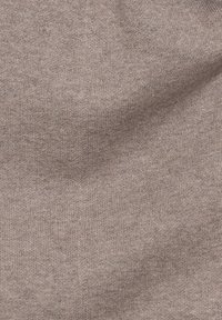 Helles taupe gestricktes Material mit weicher Textur, das ein dezentes Melange-Muster und eine glatte, dehnbare Oberfläche aufweist.