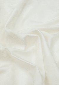 White satin fabric with a smooth texture, featuring subtle tonal patterns and folds creating gentle drapes.