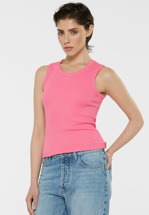 Fitted, sleeveless pink ribbed tank top, featuring a rounded neckline and textured fabric, paired with light blue high-waisted jeans.