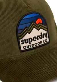 Oliwkowa czapka z teksturowanej tkaniny, z okrągłą naszywką przedstawiającą góry, zachód słońca oraz napis "superdry OUTDOOR CO."