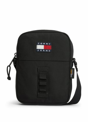 Kompaktowa czarna torba na ramię Tommy Jeans z przednią naszywką z logo, metką wykonanej z tkaniny Cordura, zamknięciem na zamek oraz regulowanym paskiem na ramię.