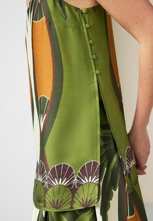 Rohelist mustrit kandva varrukateta kleidi külgvaade, millel on seljal vertikaalselt jooksvad nööbid ja alumise ääre lähedal lõhik.