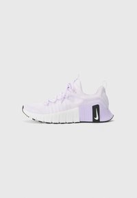 Chaussure de sport violet clair avec un dessus en maille texturée, un talon renforcé et une large semelle blanche avec un logo Nike noir.