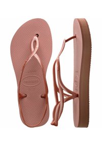 Tongs en caoutchouc rose avec une semelle intérieure texturée, des lanières tressées et une semelle moulée. Présente un bout arrondi et des bords de semelle lisses.