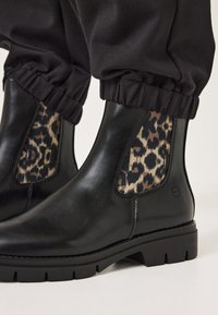 Svarta läderankelstövlar med en leopardmönstrad sidopanel, texturerad elastik upptill och en slitstark gummisula.