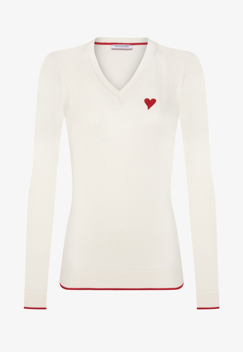 Crème kleurige gebreide trui met V-hals en lange mouwen, versierd met een klein rood hartje op de linkerborst en rode bies langs de boorden en de zoom.