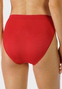 Czerwony, wysoki kostium kąpielowy z gładkiego materiału. Posiada prosty design i brak widocznych ozdób lub wzorów.