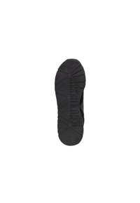 Suela negra de zapato con surcos profundos y el logo "GUESS" grabado a lo largo, presentando patrones de trillo triangulares.