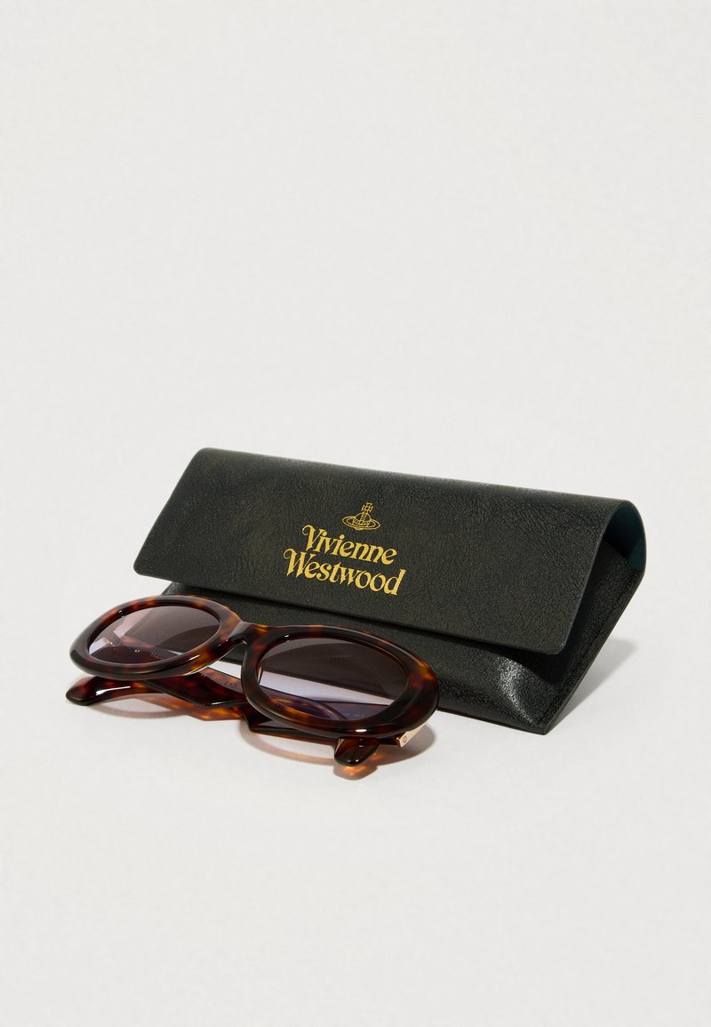 Skildpaddemønstrede solbriller med ovale stel, parret med et sort læderetui med guld "Vivienne Westwood" logo.