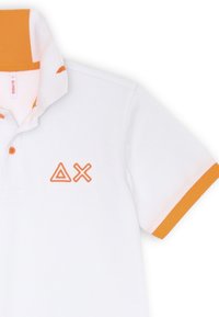 Polo bianco con colletto e accenti arancioni sulle maniche. Presenta due simboli ricamati arancioni sul petto a sinistra. Tessuto testurizzato.
