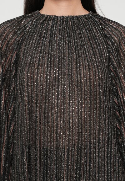 Blusa nera plissettata con strisce metalliche verticali e scollo arricciato. Presenta un tessuto testurizzato e luminoso con paillettes.