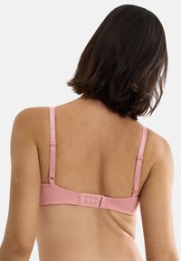 Ροζ σουτιέν με ρυθμιζόμενες τιράντες και κλείσιμο με γάντζο και ματάκι στο πίσω μέρος. Ομαλό ύφασμα με μίνιμαλ σχεδιασμό και διακριτική γυαλάδα.