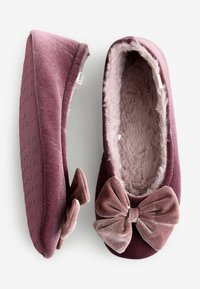 Velvet slipper in deep burgundy features a soft faux fur lining, rounded shape, and a prominent bow accent on the front.
