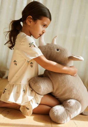 Blød beige plysdyr med øjne og horn, omfavnet af et barn i en lys, blomsterpræget kjole. Varm belysning fremhæver teksturer og detaljer.