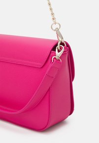 Horkorůžová strukturovaná kabelka s texturovaným koženým povrchem, magnetickým uzávěrem a zlatým řetízkem. Disponuje elegantním, ostrým designem.