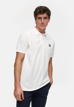 Witte polo met een kraag, korte mouwen en een klein zwart logo op de borst. Glad, lichtgewicht materiaal en een klassieke pasvorm.