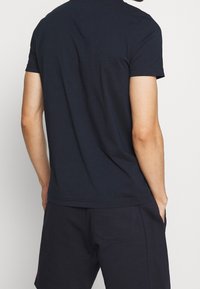 Navy blue short-sleeve t-shirt made of cotton, featuring a round neckline and a relaxed fit, with minimal seams and no visible branding.