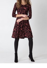Black floral dress with three-quarter sleeves and a fitted bodice that flares at the waist, featuring a textured pattern in pink flowers.
