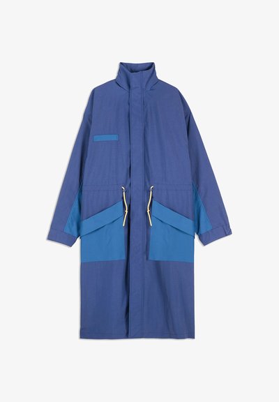 Long blue coat with high collar, front zipper, two large flap pockets with yellow drawstrings, and a small chest pocket.