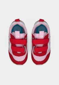 Ζευγάρι παιδικά ροζ και κόκκινα αθλητικά παπούτσια με λουριά Velcro και λευκό λογότυπο αστέρι, από ψηλά πάνω σε λευκό φόντο.