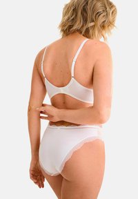Witte lingerieset bestaande uit een kantafgewerkte bh en bijpassende hoog-waisted slipjes. Zacht materiaal met verstelbare banden en delicate kantaccenten.