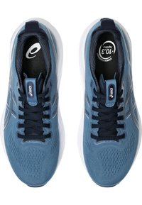 Scarpe da ginnastica blu con una tomaia texturizzata, lacci navy, accenti riflettenti argentati e una suola bianca, dotate di una soletta imbottita.