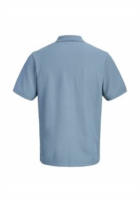Ανοιχτό μπλε κοντομάνικο πόλο πουκάμισο, εμφανιζόμενο από πίσω, με απλή υφή και κλασικό γιακά.