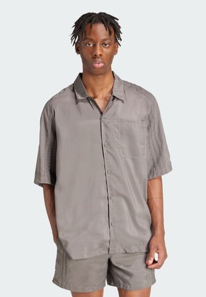 Gray short-sleeve button-up shirt with a front pocket, smooth texture, and slightly loose fit, paired with matching shorts.