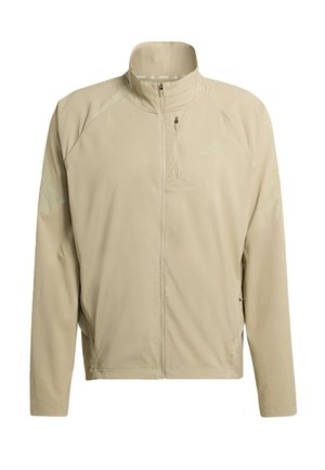 Béžová bežecká bunda s vysokým golierom, celým predným zipsom a dvomi bočnými vreckami; obsahuje jemné logá a priedušnú textúru tkaniny.