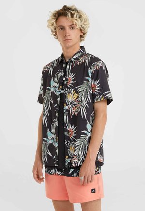 Short-sleeve black shirt with colorful tropical floral pattern; paired with pink shorts that feature a small logo patch on the side.