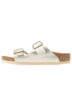 Metallic gold slide sandal with two adjustable straps, cork footbed, and light rubber sole; smooth appearance with a flat design.